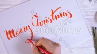 恭喜你圣诞快乐。 书法家在白牌上用红墨水写字. 书法。 装饰字体。 艺术